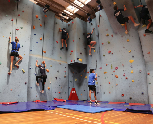 Sieben Schüler an der großen neuen Kletterwand der Trident High School