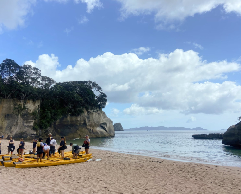 Eine Gruppe Trident High School Schüler mach in der Cathedral Cove ihre Kayaks fertig