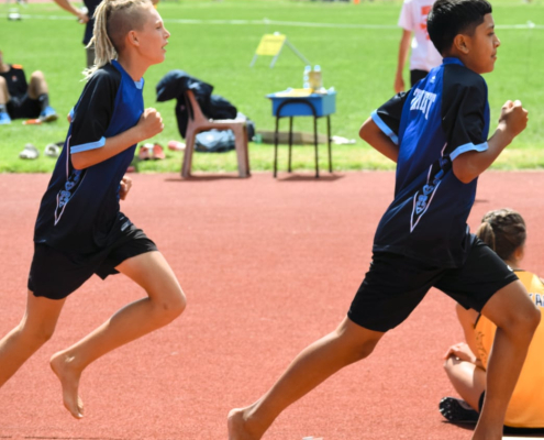 Zwei Schüler der Trident High School rennen auf dem Sportplatz