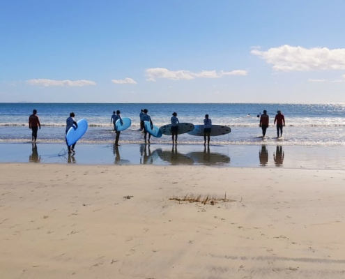 Eine Gruppe Surfer auf dem Weg ins Meer
